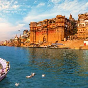 Scenic view of Varanasi Ghats and historic buildings along the Ganges River with traditional boats